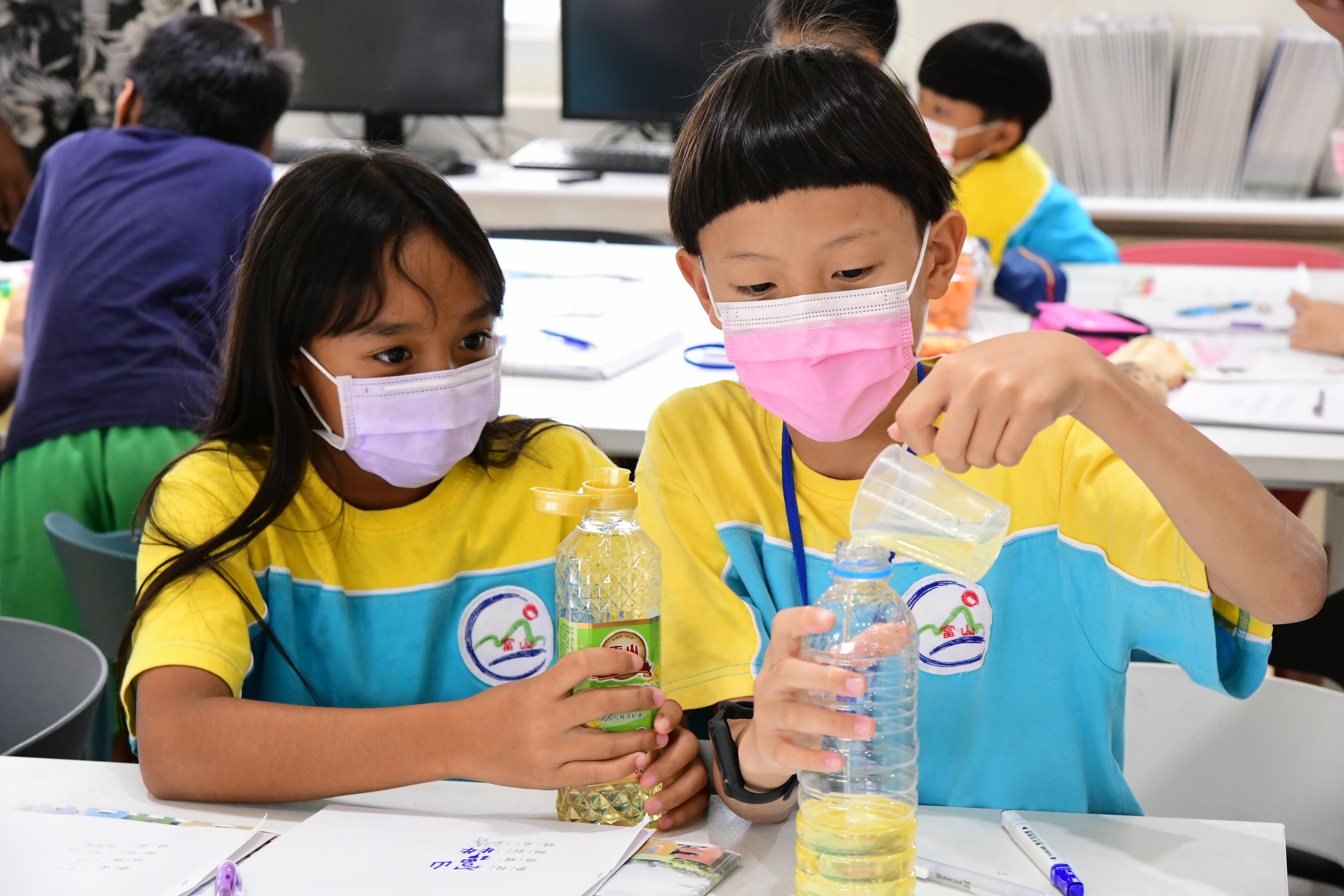 Students making a sunflower oil-based insect repellant.