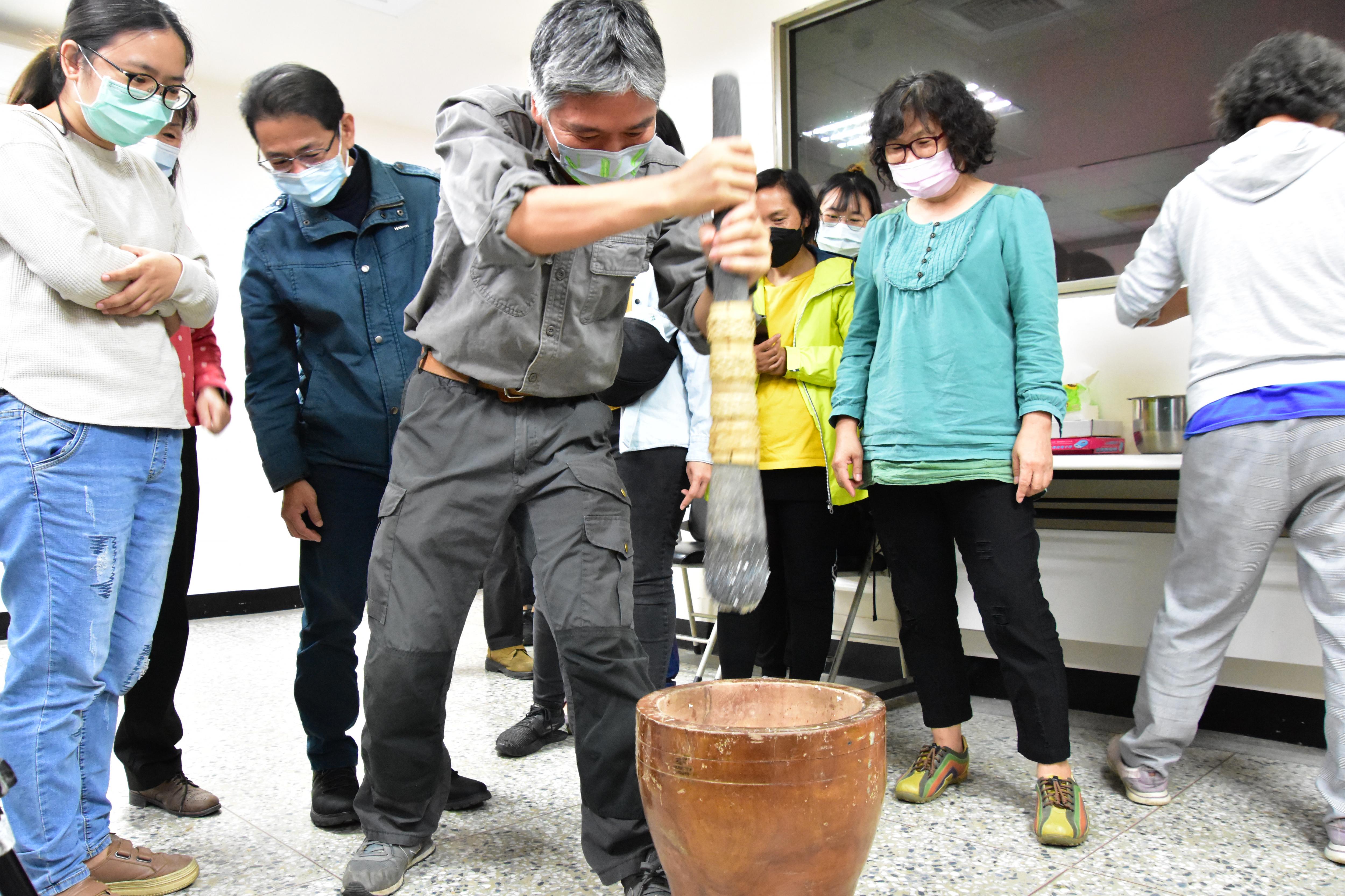 Figure 2. TTDARES staff members take turns pounding rice with a pestle to make rice flour.