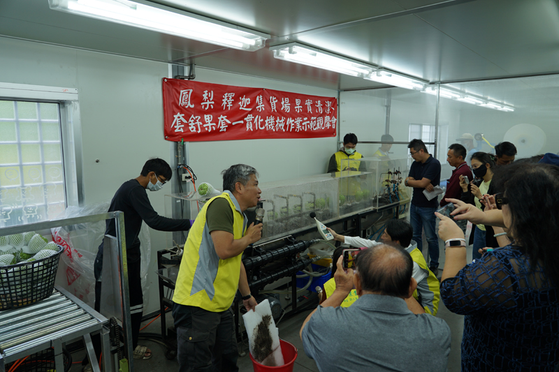 Figure 2. Associate researcher Huang Cheng-lung shows how to use the all-in-one cleaning and sleeving machinery.