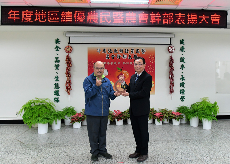 Director Chen presents farmer Liang Cheng-hsian with a 34th National Model Farmer trophy.