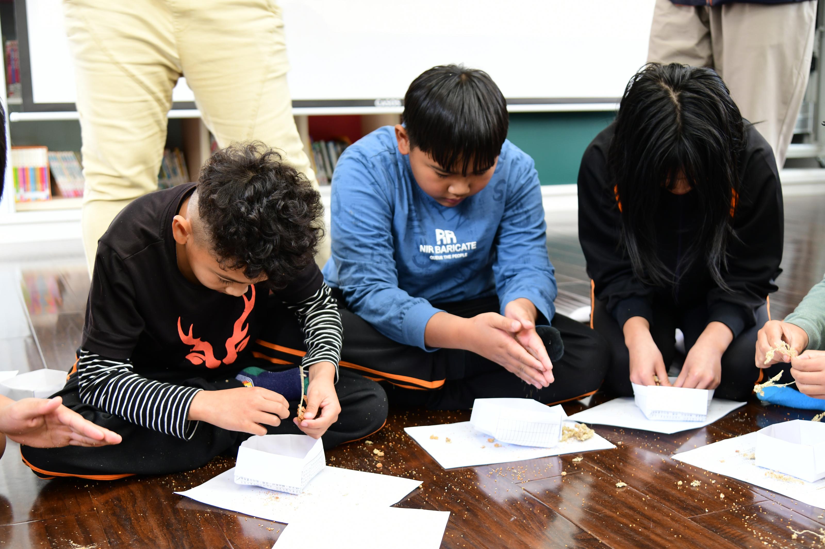 Students husking millet.