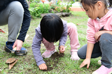 The instructor showing students how to plant pigeon pea seeds.