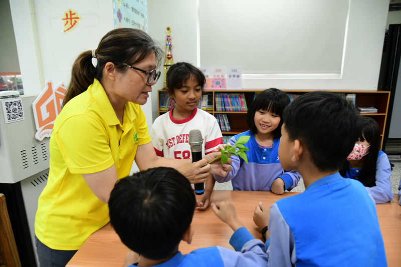 The instructor showing students how to pinch off unwanted buds to control growth.