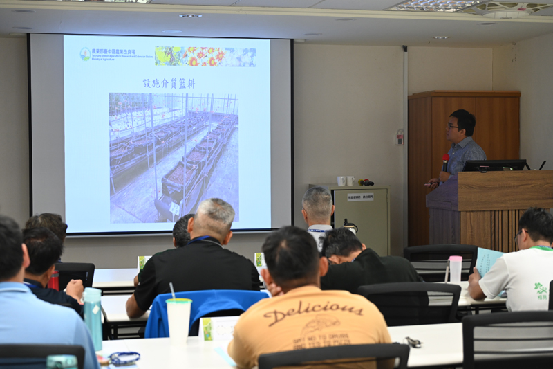 Associate researcher Lin Yu-heng of the Taichung DARES discusses vegetable cultivation techniques within a net house.